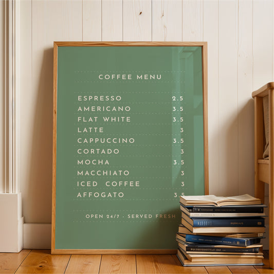 A green framed coffee menu board displaying a variety of coffee drinks, placed next to a stack of books on a wooden floor.