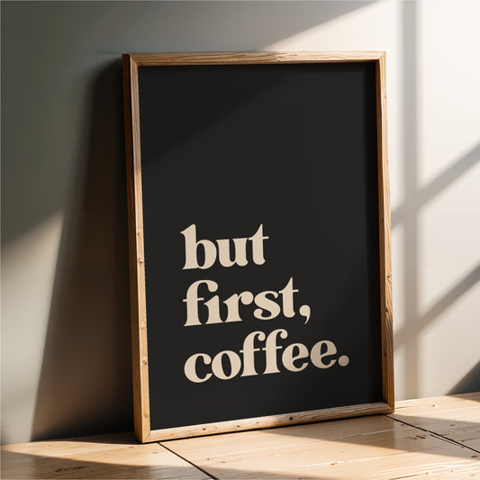 A framed poster with the text "but first, coffee" on it, leaning against a wall.
