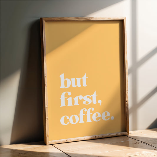 A framed poster with the text "but first, coffee" on it, leaning against a wall.