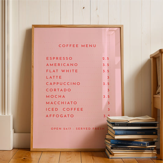 A pink framed menu board displaying a coffee menu, with a stack of books and a wooden shelf visible in the background.