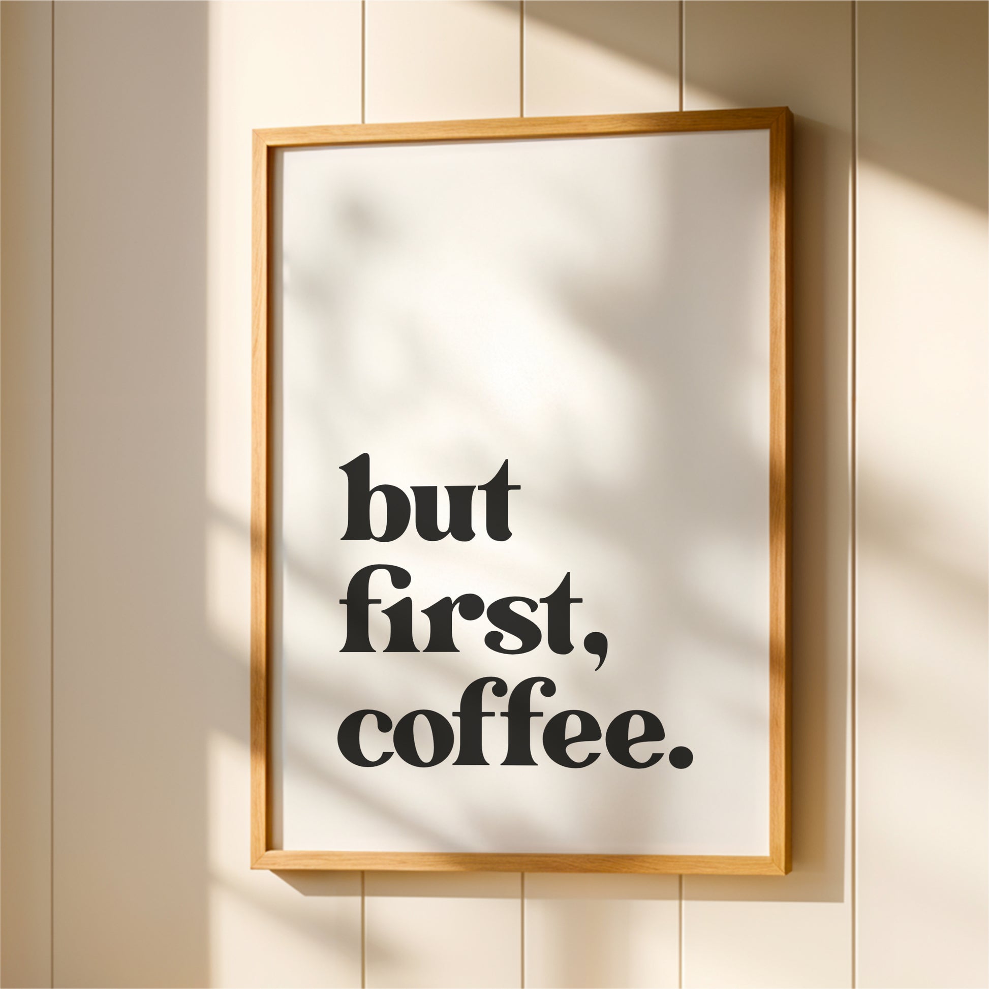A framed poster with the text "but first, coffee."