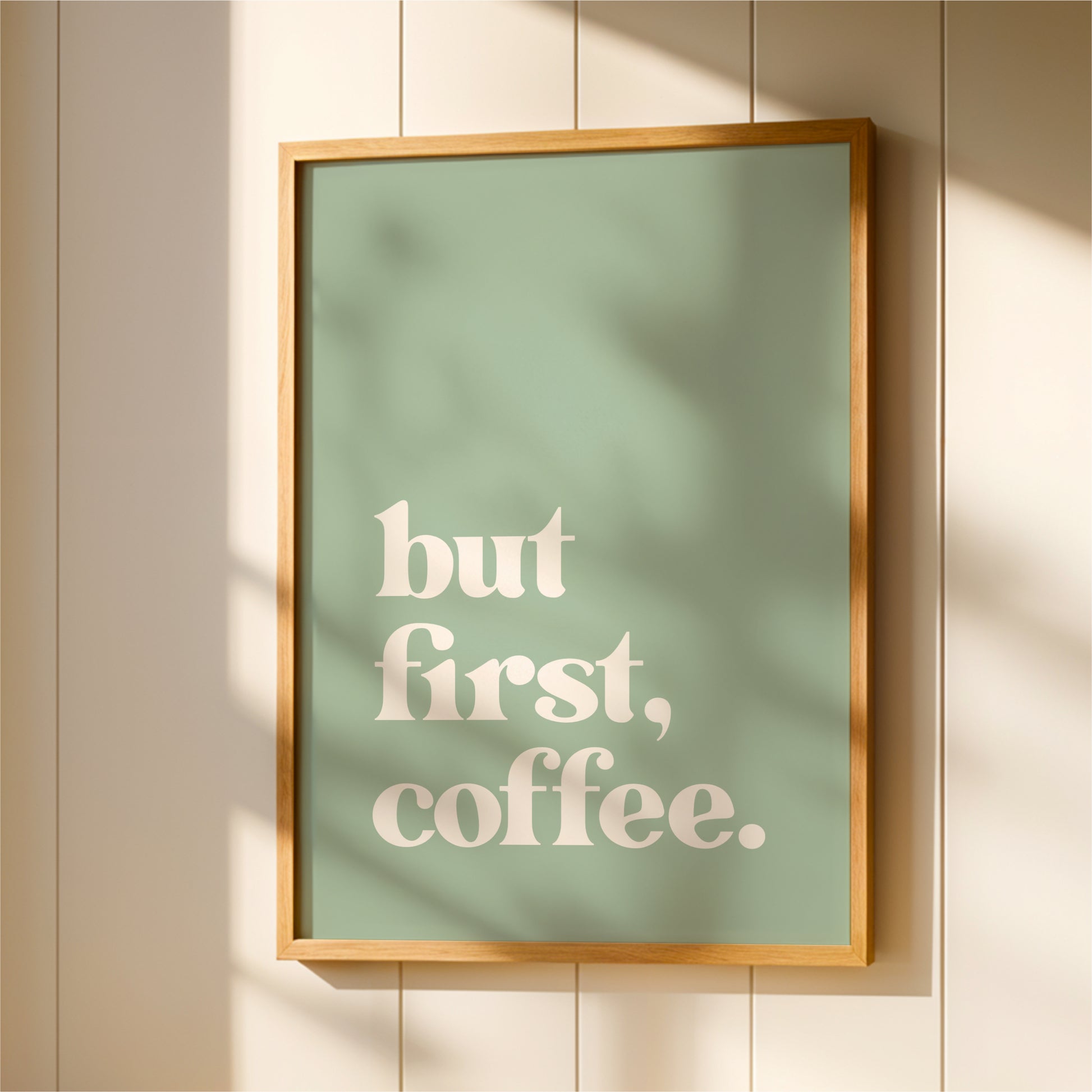 A framed poster with the text "but first, coffee."