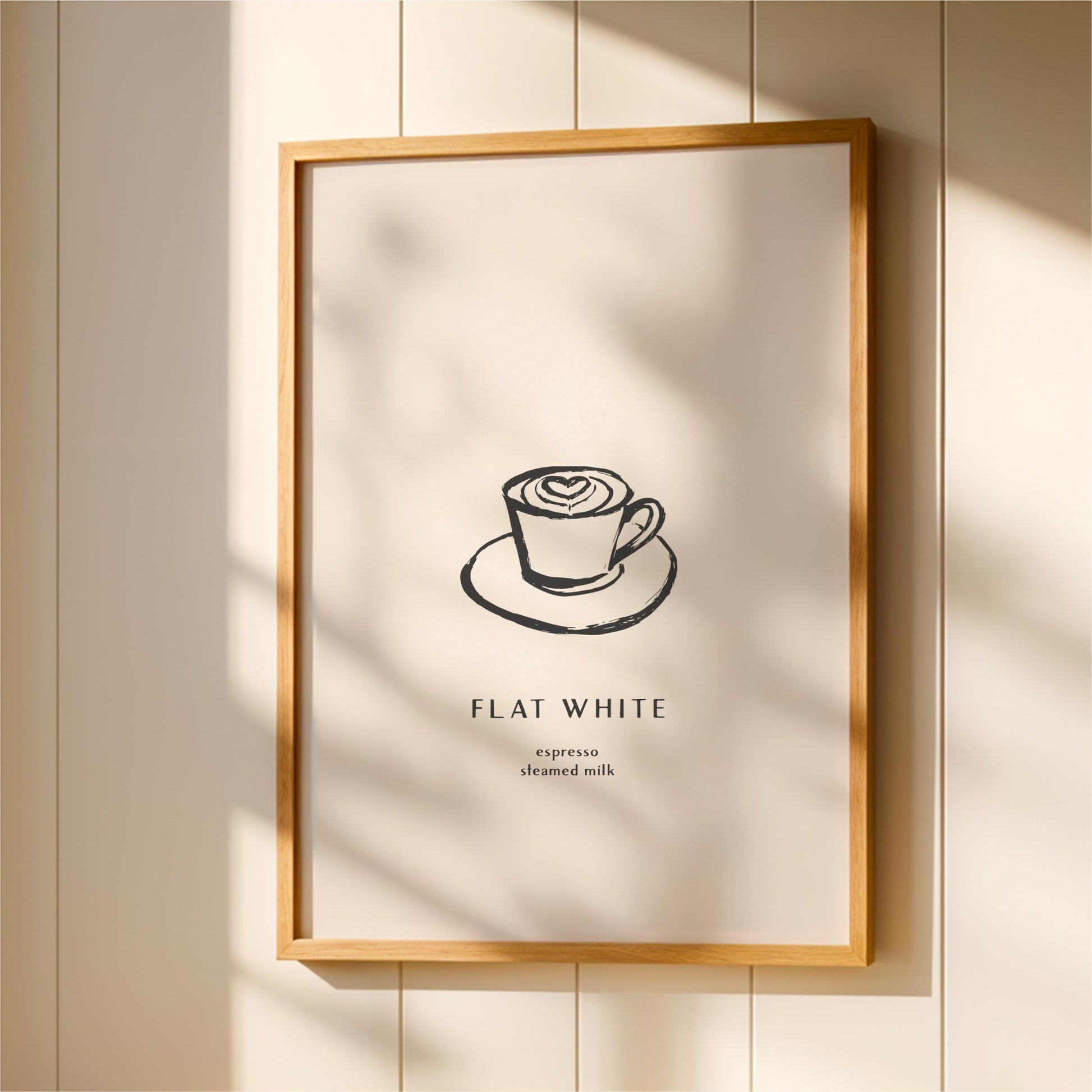 a framed poster with a simple illustration of a cup of coffee on a saucer, accompanied by the text "FLAT WHITE espresso milk".