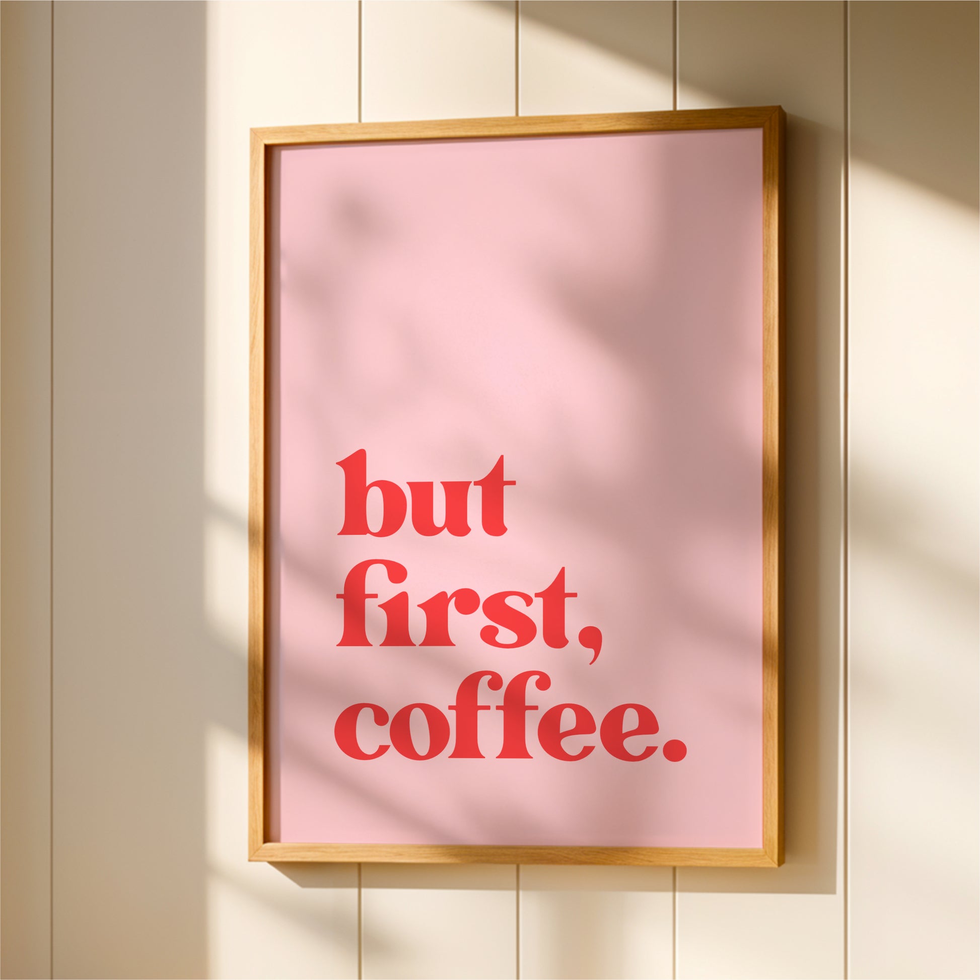 A framed poster with the text "but first, coffee."