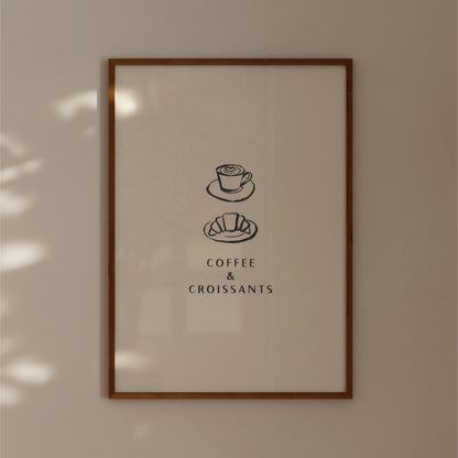 The image is a framed poster with a simple design featuring a cup of coffee and a croissant, accompanied by the text "COFFEE & CROISSANTS".