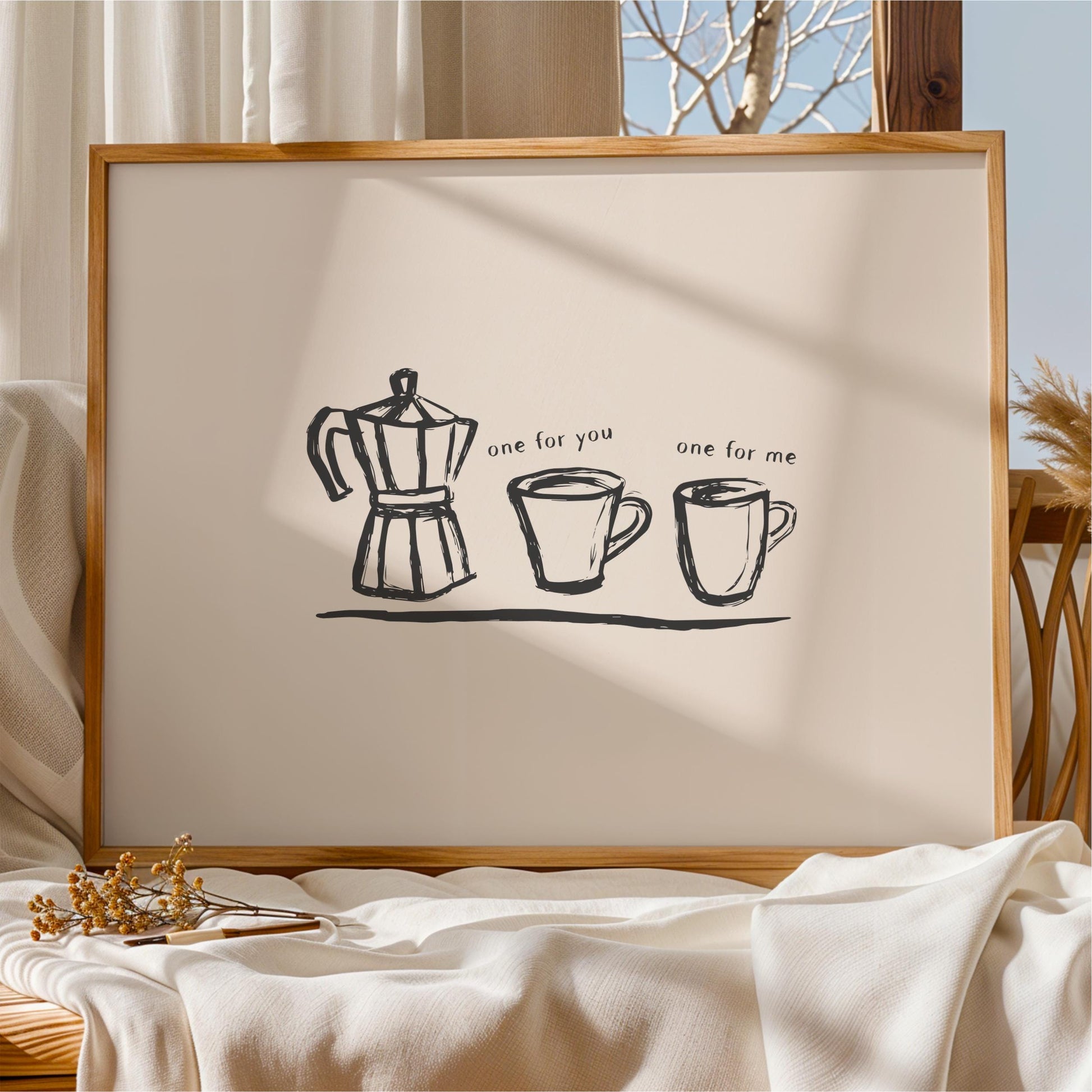 a framed artwork with a simple black and white illustration of a coffee maker, two mugs, and the text "one for you one for me" written below the illustration.