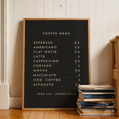 A black coffee menu board with a list of coffee drinks and their prices, placed on a wooden floor next to a stack of books.