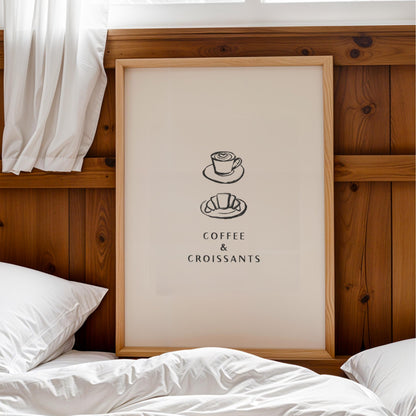a framed poster with a coffee and croissant illustration on it, placed on a wooden headboard above a bed with white pillows.
