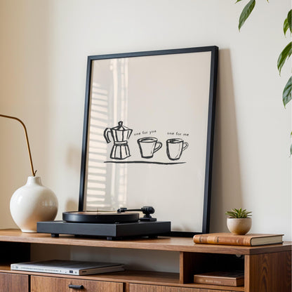 a framed poster with a simple black and white illustration of a coffee pot and two cups, accompanied by the text "one for you one for me". The poster is displayed on a wooden shelf, which also holds a record player and some books.