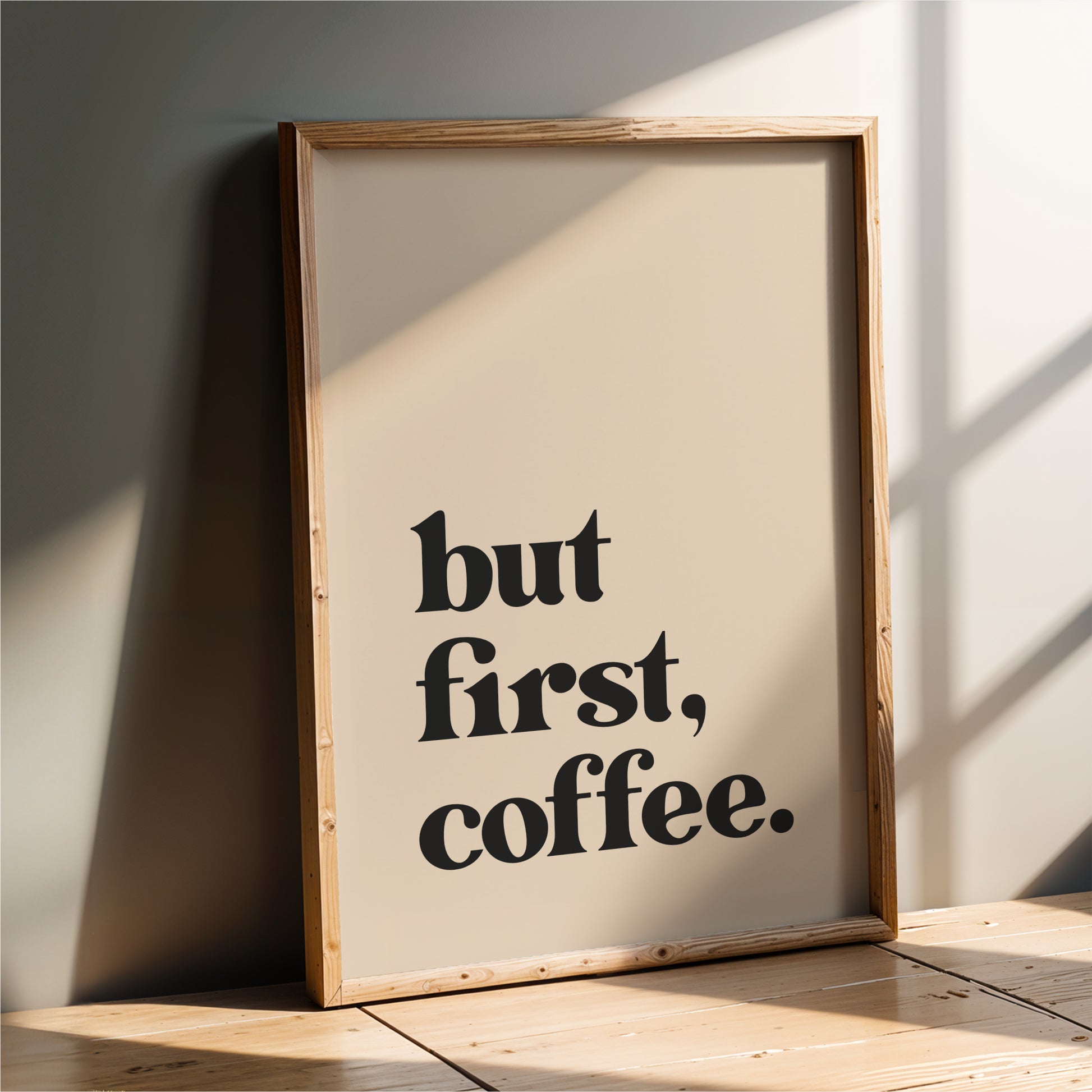 A framed poster with the text "but first, coffee."