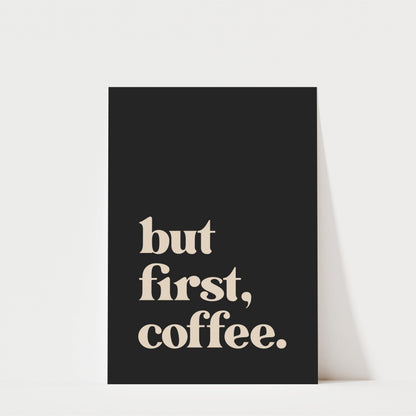 A black poster with the text "but first, coffee." printed on it.