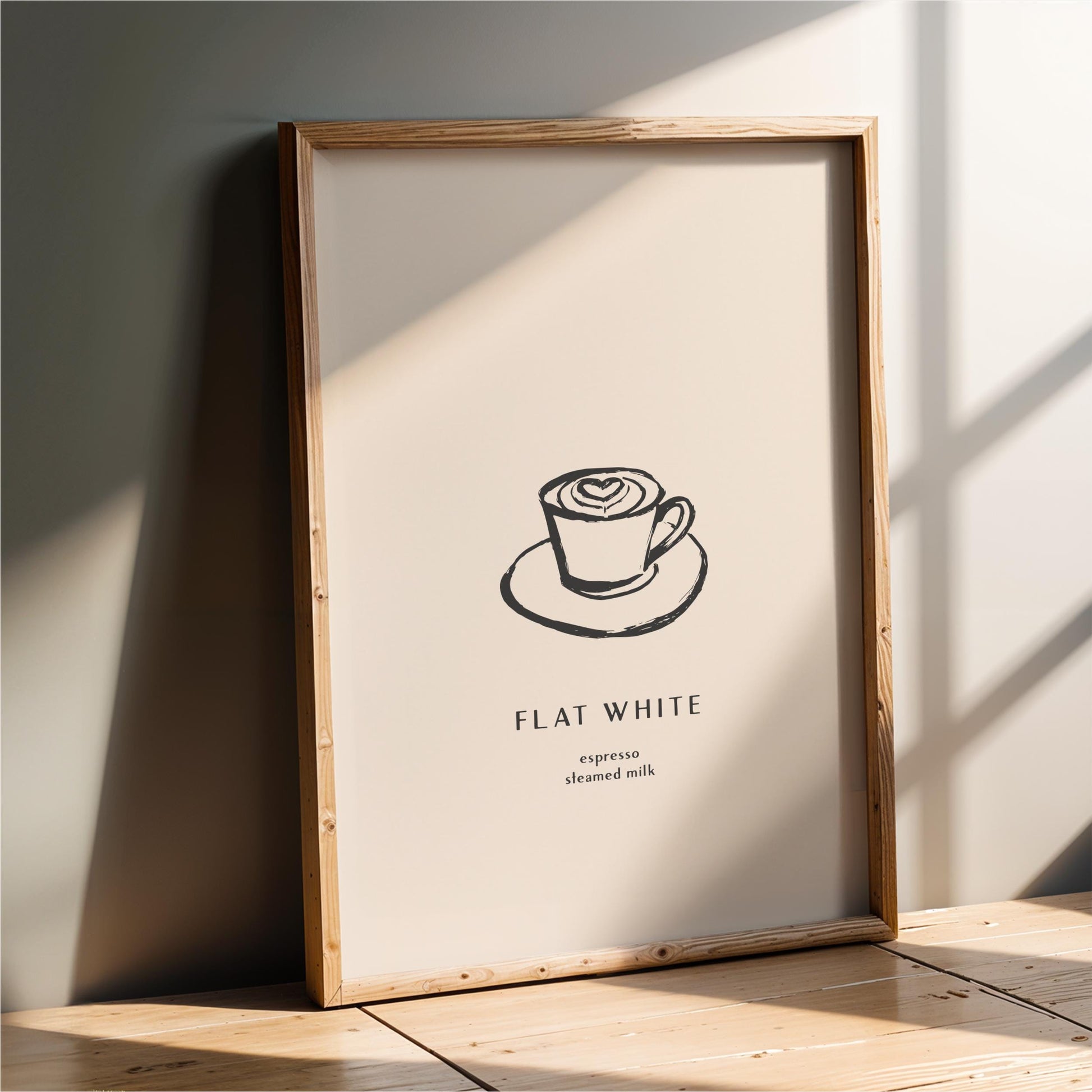 a framed poster with a simple black and white illustration of a cup of coffee on a saucer, along with the text "FLAT WHITE" and "expression steeped milk" below it.