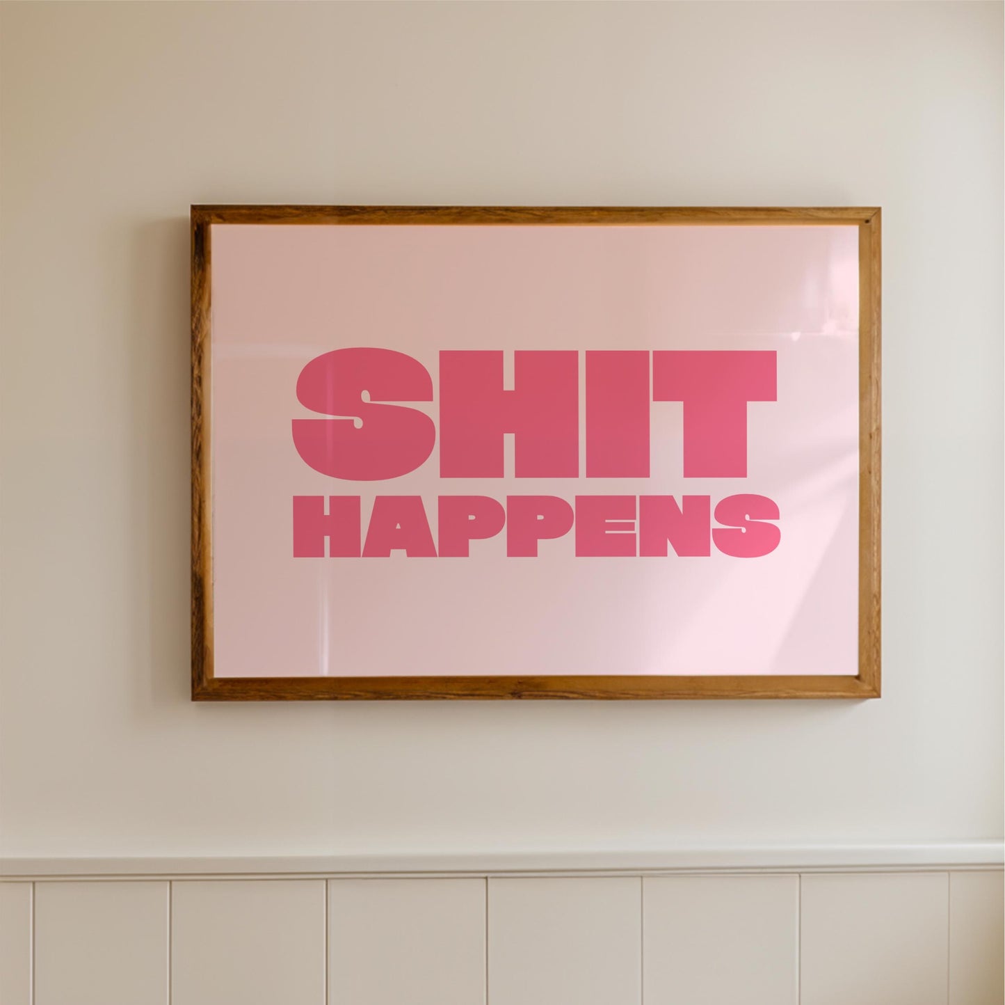 a framed poster with the text "SHIT HAPPENS" in bold pink letters.