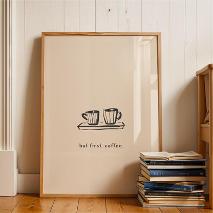 A framed poster with the text "but first. coffee" is displayed on a wall next to a stack of books.