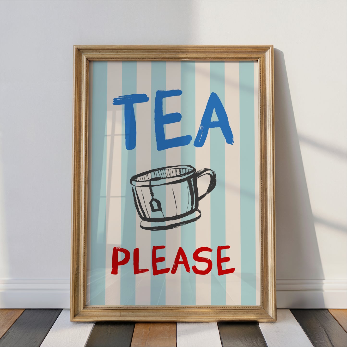 A framed poster with the text "TEA PLEASE" and an illustration of a cup, placed on a wooden floor against a white wall.