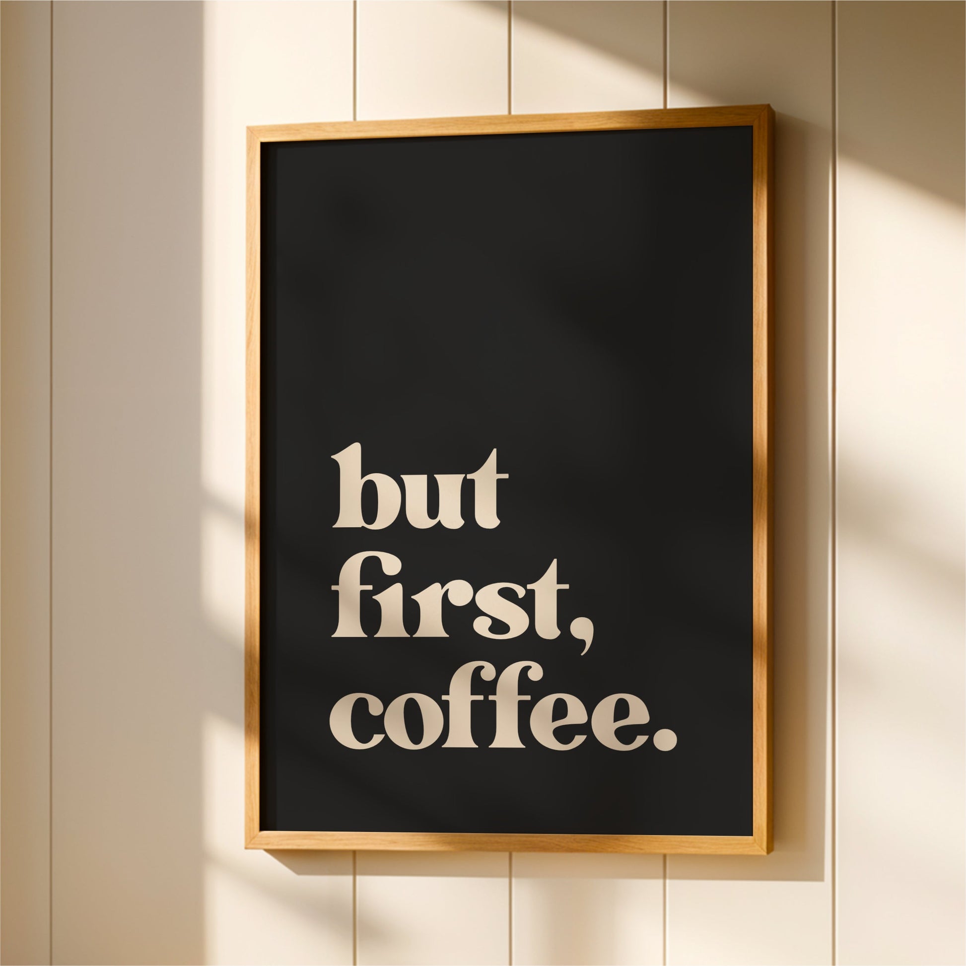 A framed poster with the text "but first, coffee."