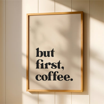 A framed poster with the text "but first, coffee."