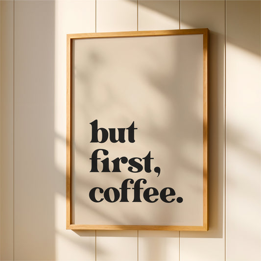 A framed poster with the text "but first, coffee."