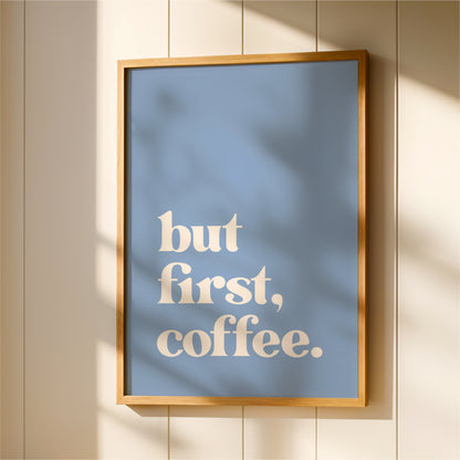 A framed poster with the text "but first, coffee."