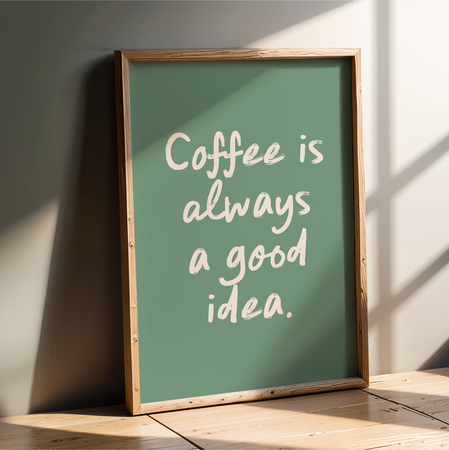 A framed poster with the text "Coffee is always a good idea" on a green background.