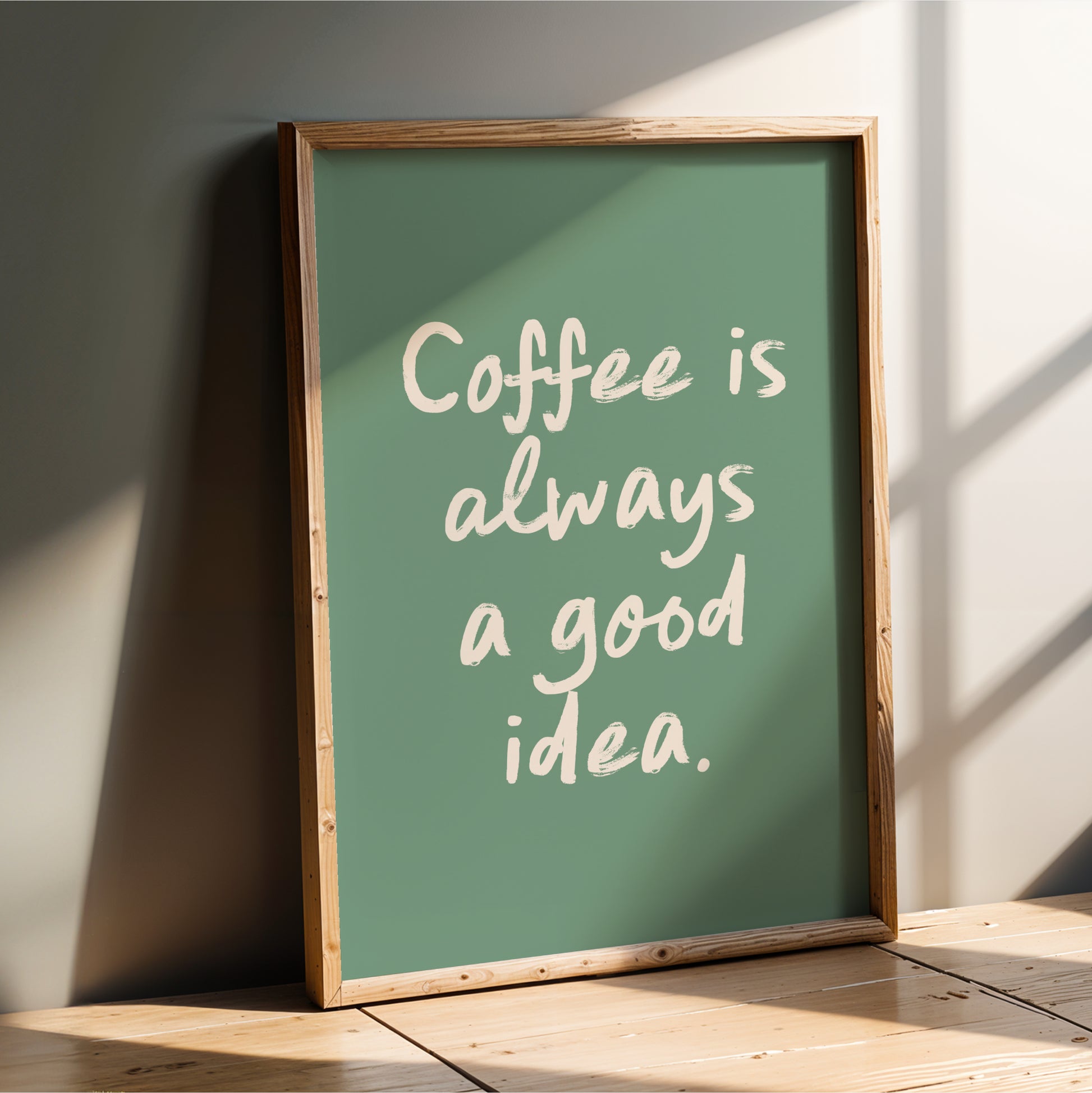 A framed poster with the text "Coffee is always a good idea" on a green background.