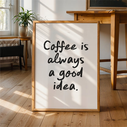 A framed sign with the text "Coffee is always a good idea" is displayed in a room with a wooden table and chair.