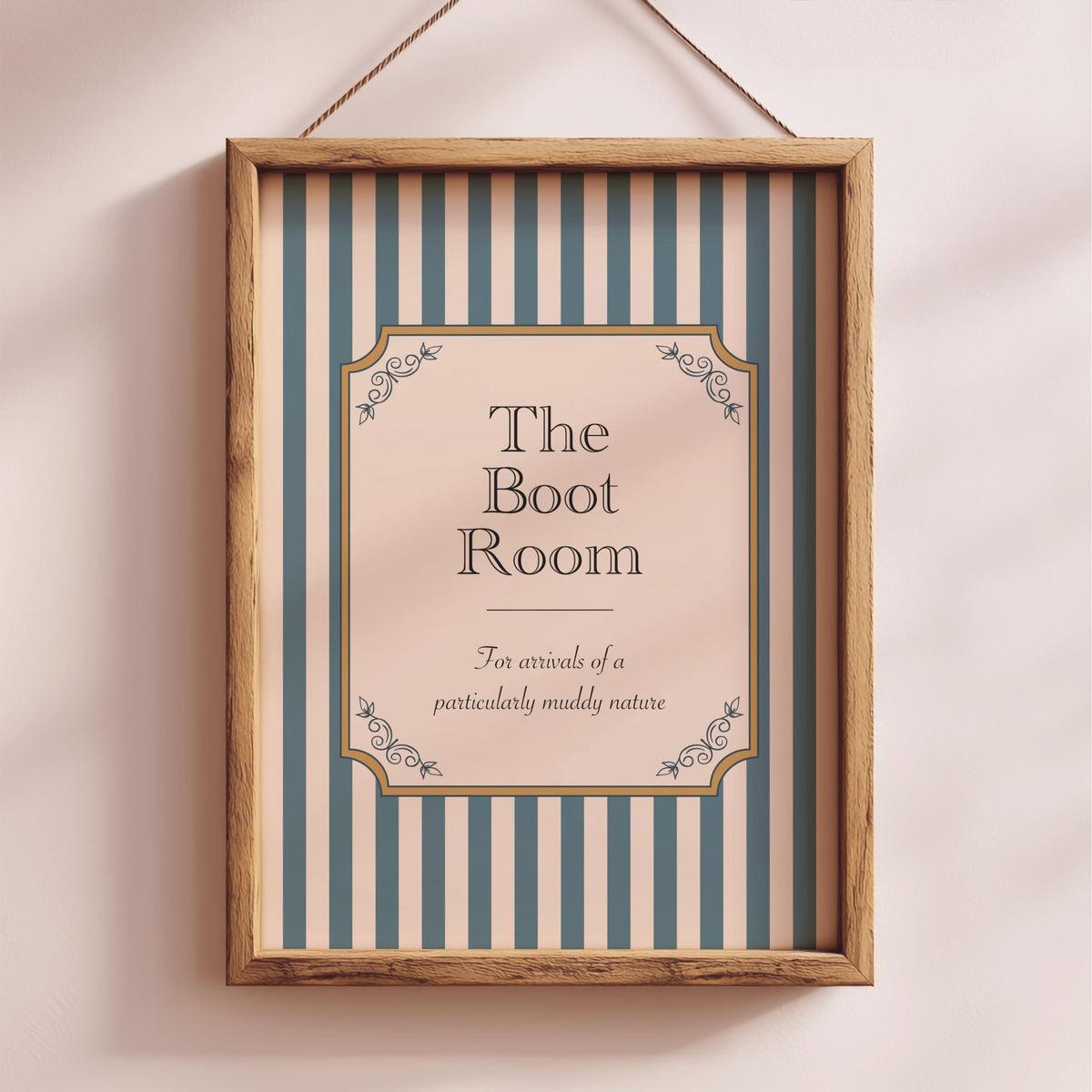 a framed sign with the text "The Boot Room" and decorative elements, hanging on a wall.