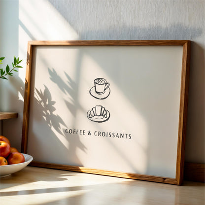 A framed poster with the text "COFFEE & CROISSANTS" and two illustrations of a coffee cup and a croissant.