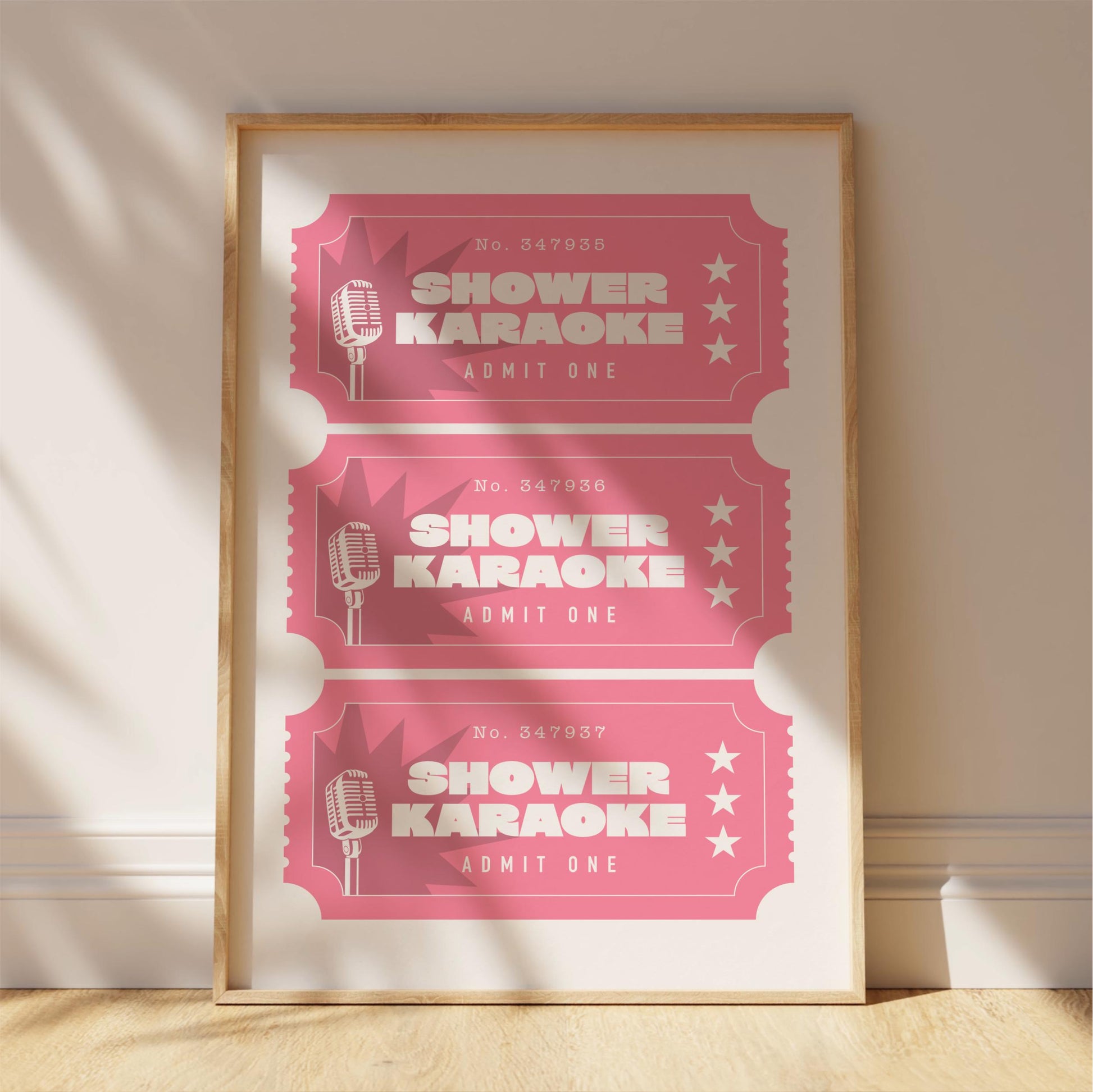 A framed poster advertising "Shower Karaoke" event tickets, with three tickets displayed in a pink color.