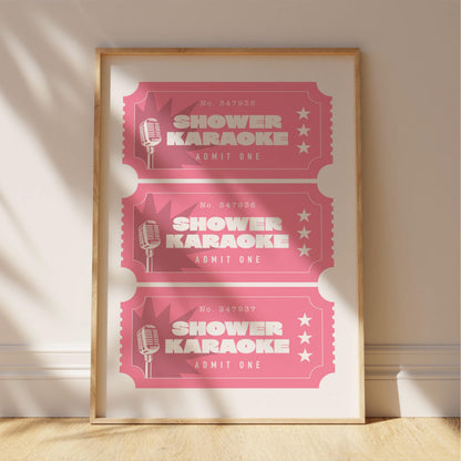 A framed poster advertising "Shower Karaoke" event tickets, with three tickets displayed in a pink color.