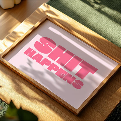 a framed poster with the text "SHIT HAPPENS" in bold pink letters.