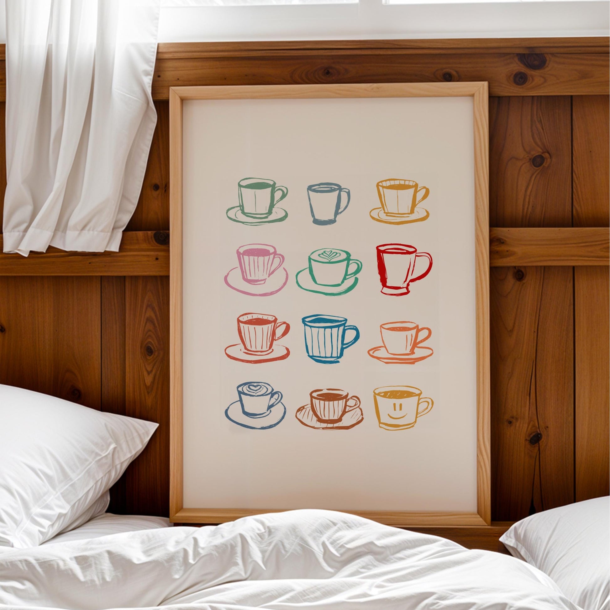 a framed print of colorful coffee cups and saucers on a wooden wall above a bed with white pillows.