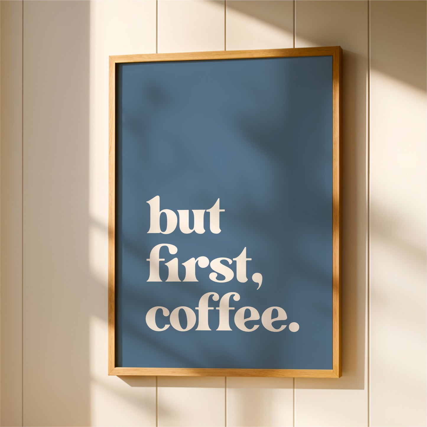 A framed poster with the text "but first, coffee."